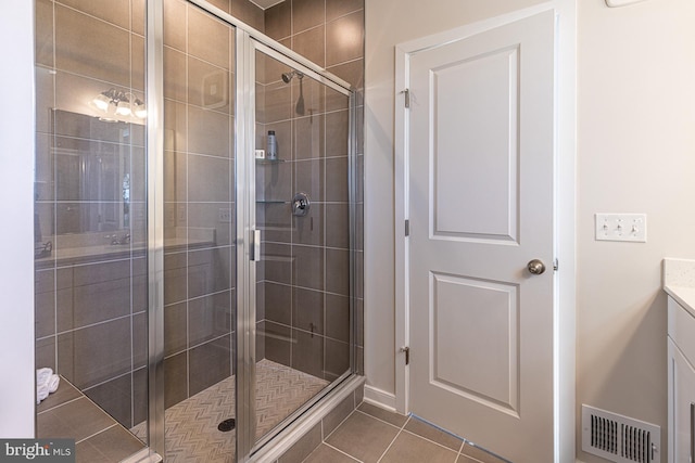 full bathroom with vanity, a stall shower, tile patterned flooring, and visible vents