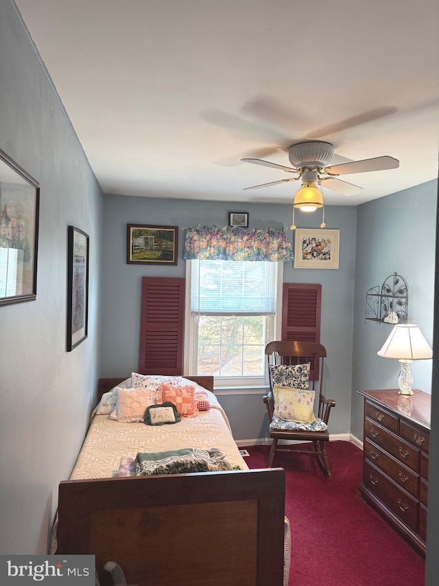 bedroom with ceiling fan, dark carpet, and baseboards