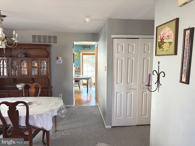 dining space featuring carpet floors, baseboards, visible vents, and a chandelier