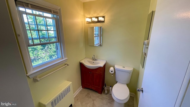 bathroom featuring toilet, plenty of natural light, radiator heating unit, and vanity