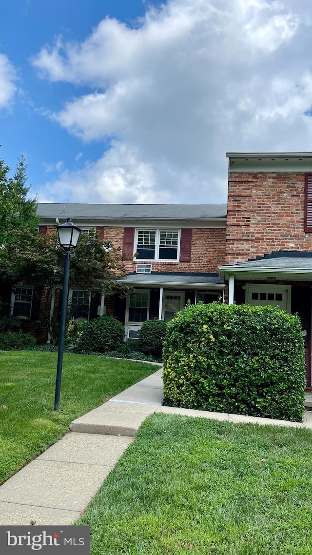 view of front of home with brick siding and a front lawn