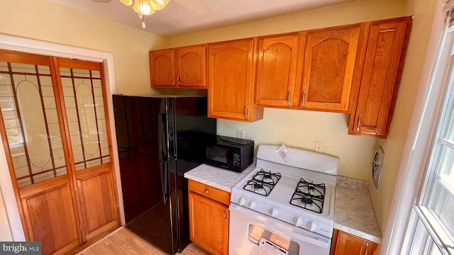 kitchen with black appliances, light countertops, and brown cabinets