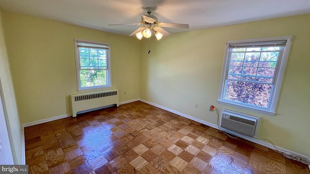 unfurnished room with ceiling fan, radiator heating unit, a wall unit AC, and baseboards