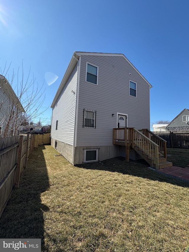 rear view of house with a lawn and a fenced backyard