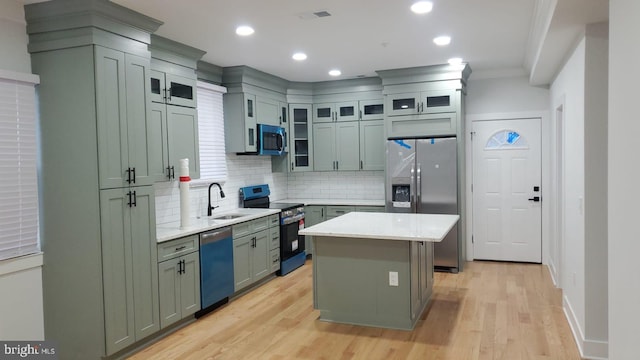 kitchen featuring stainless steel appliances, visible vents, a sink, and light wood finished floors