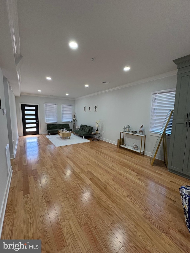 workout room with light wood finished floors, baseboards, ornamental molding, and recessed lighting