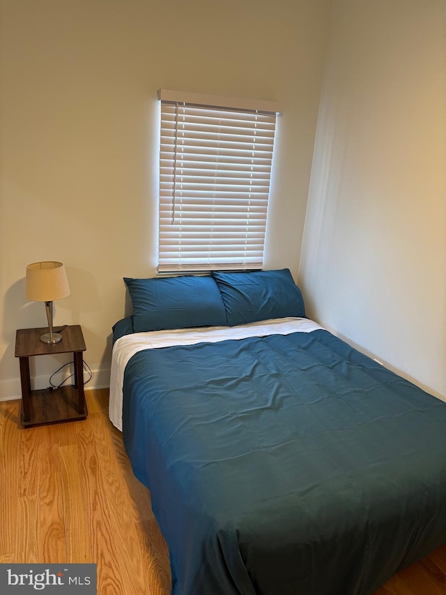 bedroom with wood finished floors and baseboards