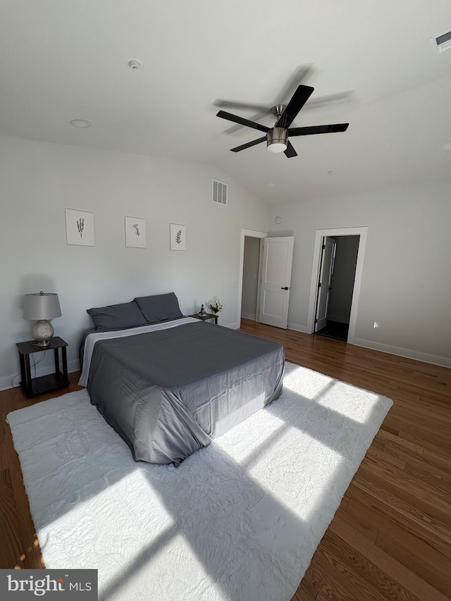 bedroom featuring lofted ceiling, visible vents, ceiling fan, wood finished floors, and baseboards