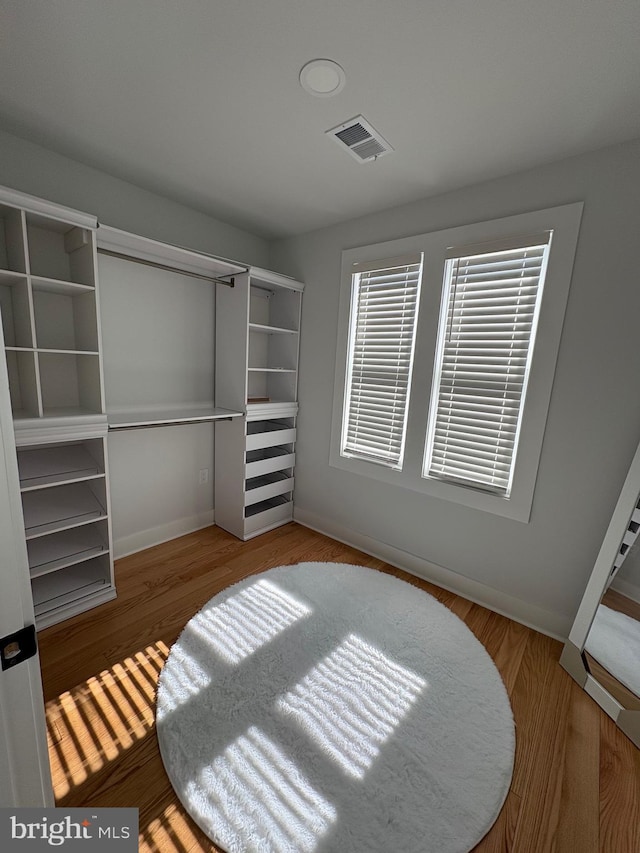 interior space featuring wood finished floors, visible vents, and baseboards