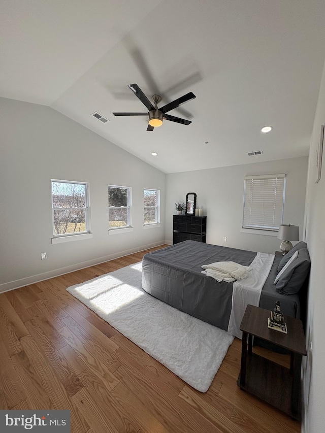 bedroom with lofted ceiling, visible vents, and wood finished floors