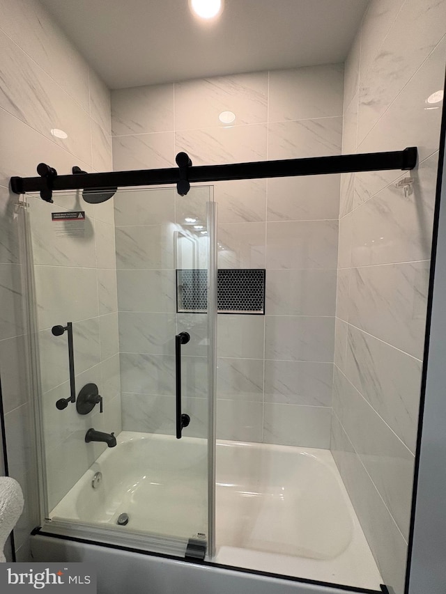 bathroom featuring combined bath / shower with glass door