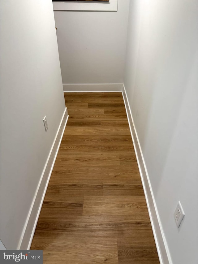 hallway with baseboards and wood finished floors