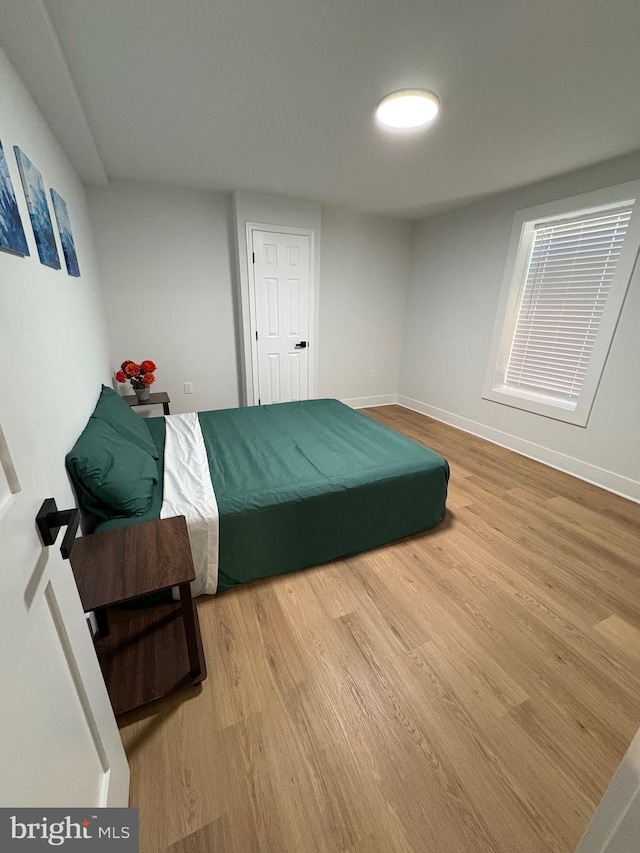 bedroom with wood finished floors and baseboards