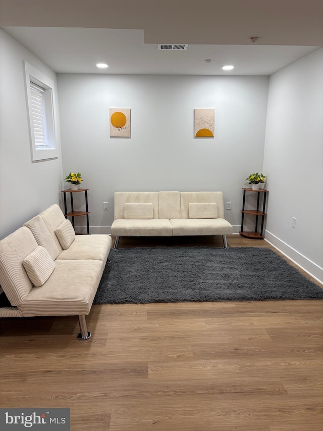 living room featuring wood finished floors, visible vents, and baseboards