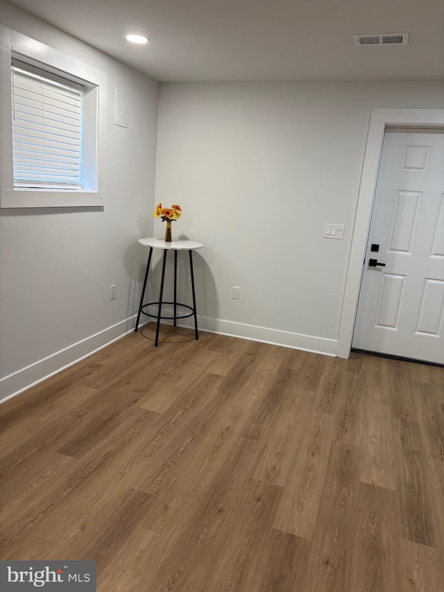 unfurnished room with recessed lighting, visible vents, baseboards, and wood finished floors