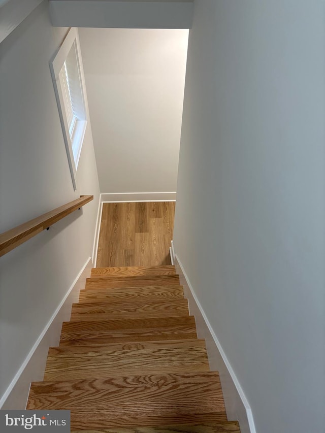 stairway with baseboards and wood finished floors