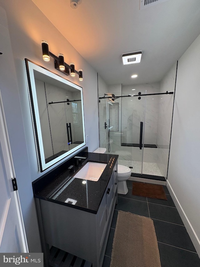 bathroom featuring toilet, vanity, baseboards, a shower stall, and tile patterned floors