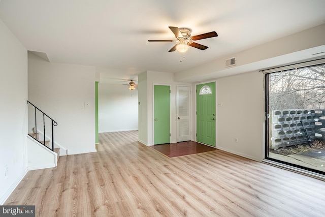 spare room featuring a ceiling fan, stairs, visible vents, and wood finished floors