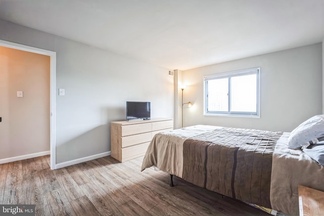 bedroom with wood finished floors and baseboards