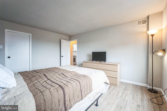 bedroom with visible vents, baseboards, and light wood-style flooring