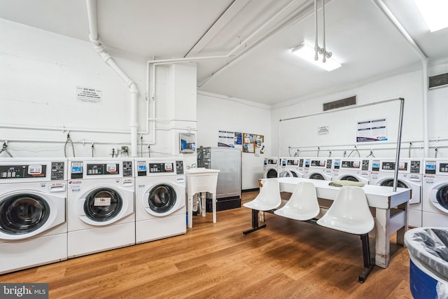 shared laundry area with wood finished floors and separate washer and dryer