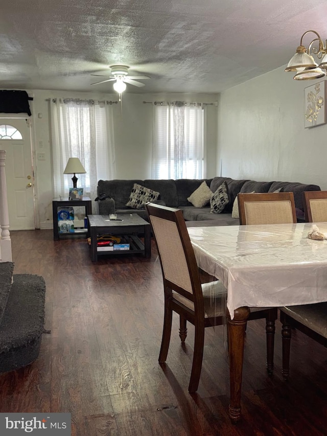 dining space with a textured ceiling, ceiling fan, and wood finished floors