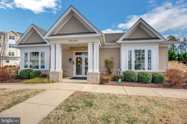 view of front of house featuring brick siding and french doors