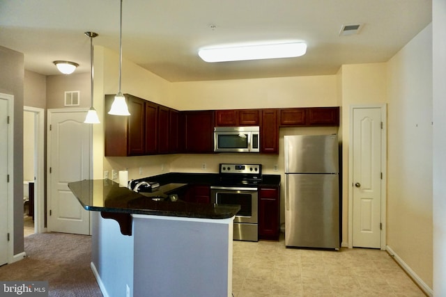 kitchen with visible vents, a peninsula, stainless steel appliances, dark brown cabinets, and dark countertops