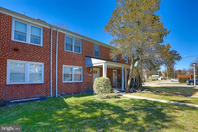 view of front of house with a front lawn and brick siding