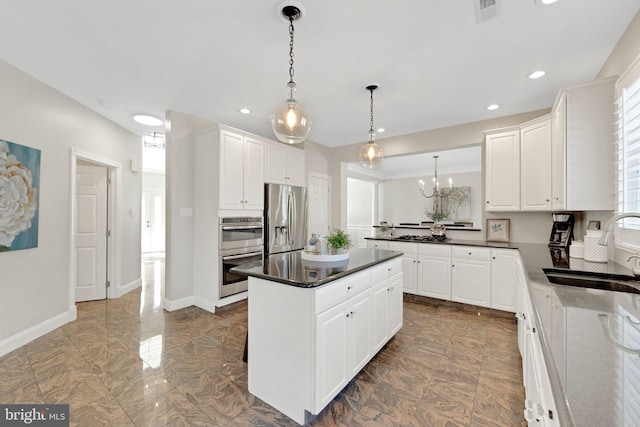 kitchen with a sink, stainless steel appliances, marble finish floor, and white cabinetry