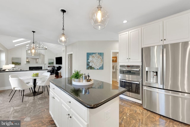 kitchen featuring lofted ceiling, a fireplace, stainless steel appliances, open floor plan, and a center island