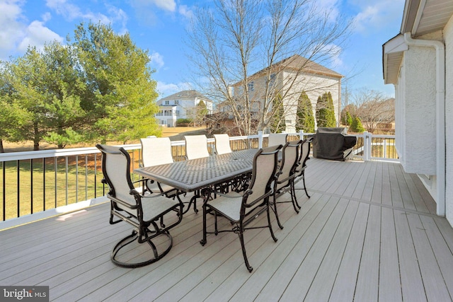 wooden terrace with outdoor dining area and a yard