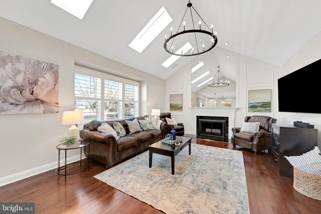 living room with a fireplace with flush hearth, high vaulted ceiling, a skylight, baseboards, and dark wood-style flooring