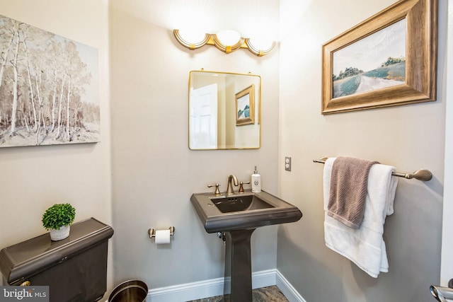 bathroom featuring baseboards and toilet