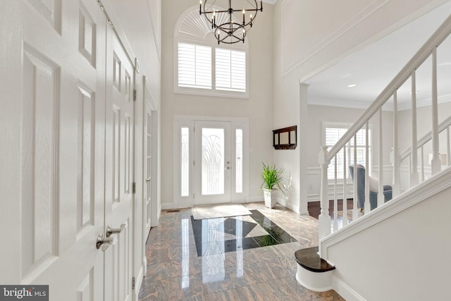 entrance foyer with stairway, baseboards, marble finish floor, and a towering ceiling