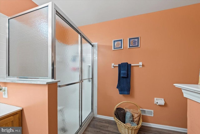 bathroom featuring a shower stall, visible vents, wood finished floors, and vanity