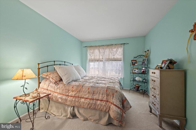 bedroom with vaulted ceiling, carpet flooring, and baseboards