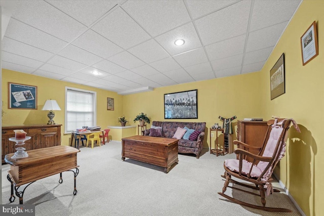 carpeted living room with a drop ceiling