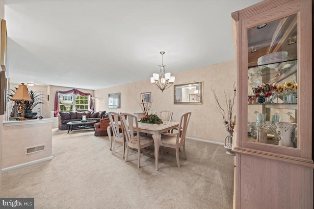 carpeted dining space with baseboards, visible vents, and a notable chandelier