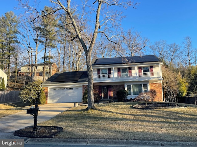 traditional home featuring brick siding, solar panels, a front yard, driveway, and an attached garage