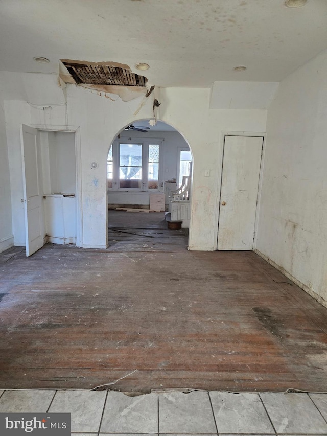 spare room with arched walkways and wood-type flooring