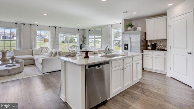 kitchen featuring light wood finished floors, appliances with stainless steel finishes, a sink, and visible vents