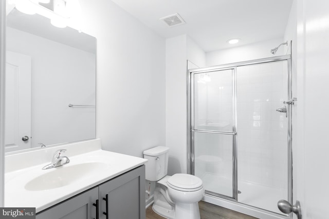 full bath with toilet, a stall shower, visible vents, and vanity