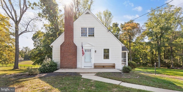 view of front of home with fence, a chimney, and a front lawn