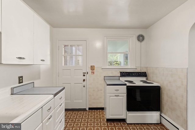 kitchen featuring arched walkways, tile walls, a baseboard radiator, electric range oven, and white cabinets