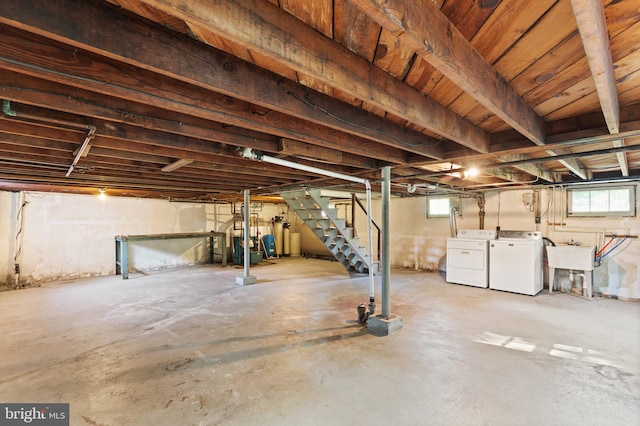 basement featuring stairs, a wealth of natural light, and separate washer and dryer