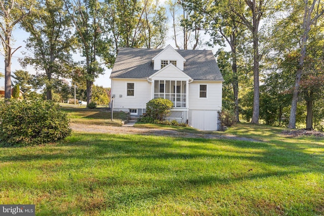 rear view of house with a sunroom and a yard