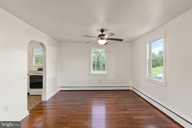 empty room with a healthy amount of sunlight, a baseboard radiator, arched walkways, and wood finished floors