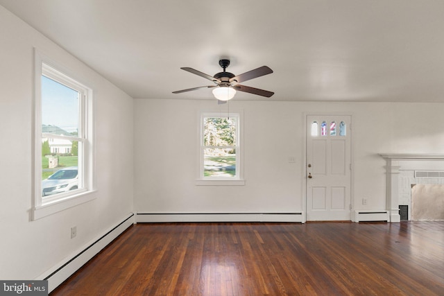 interior space with a healthy amount of sunlight, a fireplace, baseboard heating, and wood finished floors