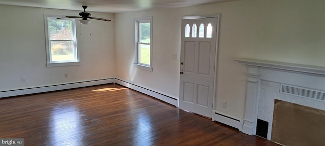 unfurnished living room featuring plenty of natural light, a brick fireplace, wood finished floors, and a baseboard radiator